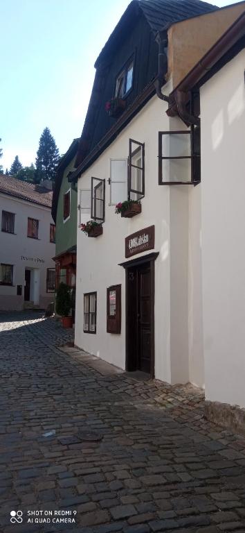un edificio bianco con una porta su una strada di ciottoli di U Kalíšku a Cesky Krumlov