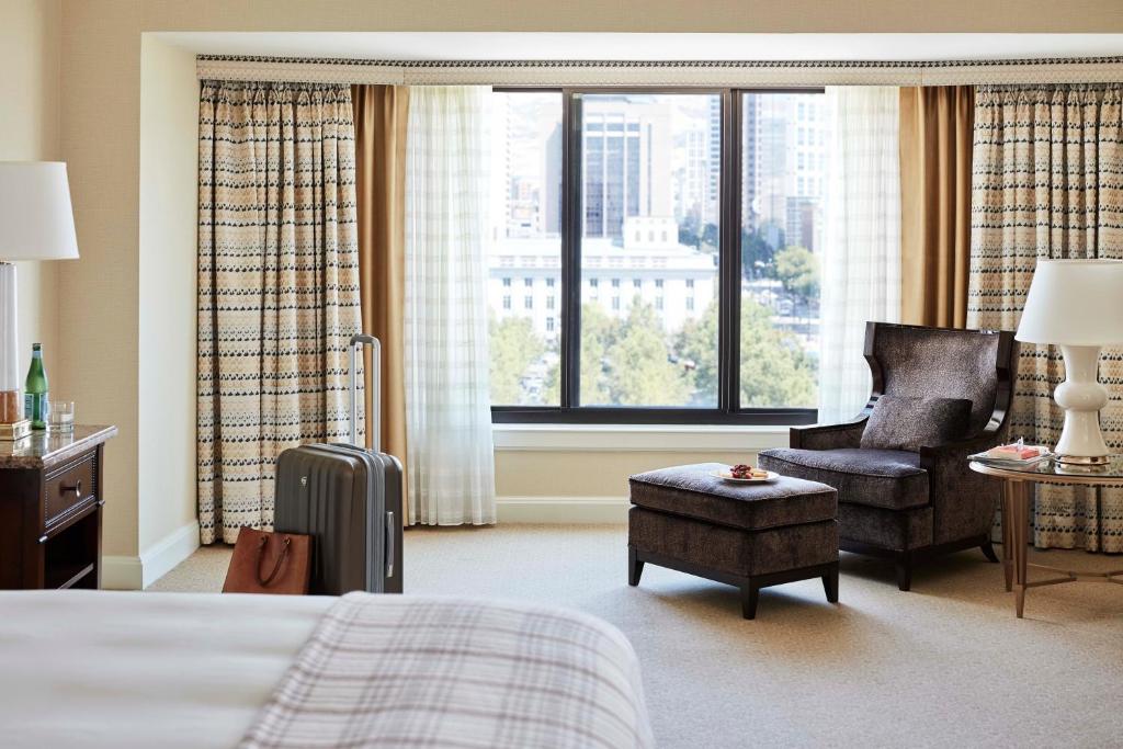 a hotel room with a bed and a chair and window at Little America Hotel Salt Lake City in Salt Lake City