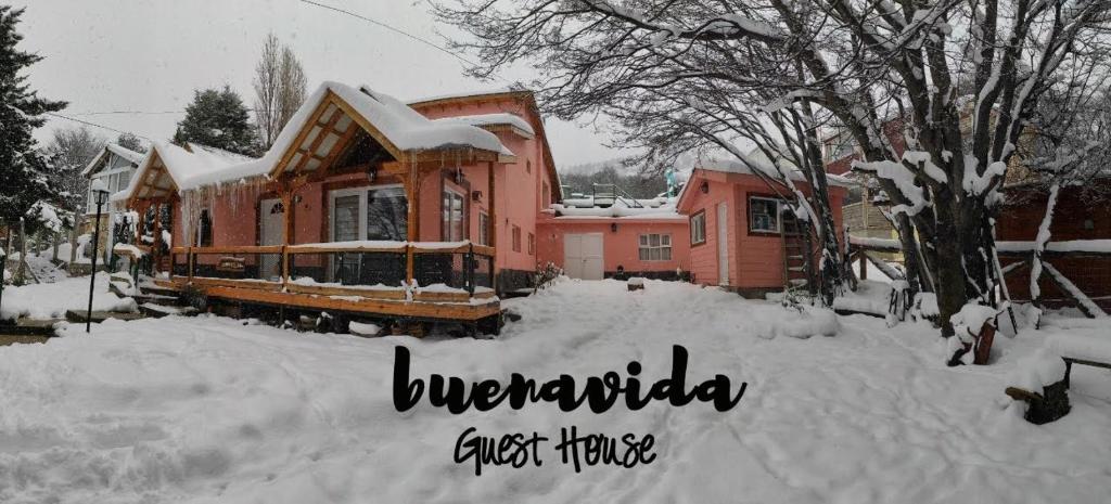 una casa está cubierta de nieve en un patio en Buenavida Guesthouse en Ushuaia