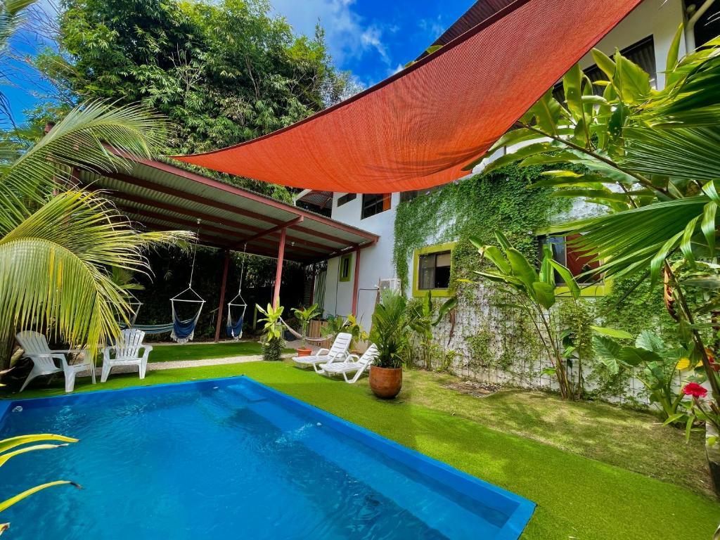 a backyard with a swimming pool and a house at Villas Jacquelina in Quepos