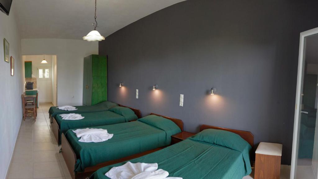 3 posti letto in una stanza con lenzuola verdi di Habitat Villa Corfu a Dassia
