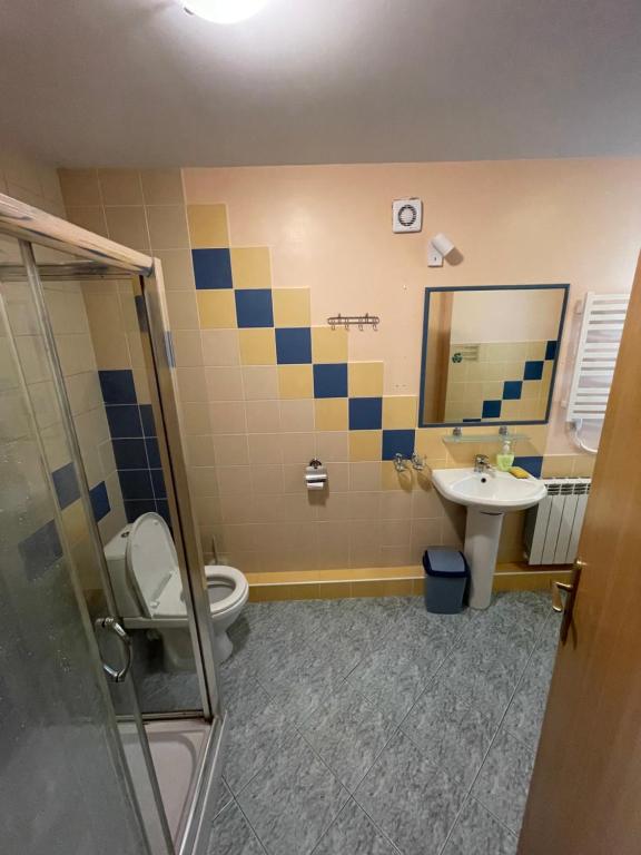 Un baño con lavabo, inodoro y espejo. en JūRa 28, en Klaipėda