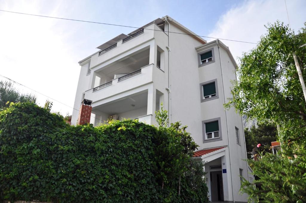 a white building with trees in front of it at Villa Ivanišević in Omiš