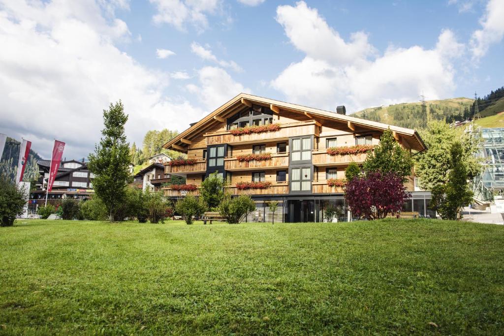 duży budynek z trawnikiem przed nim w obiekcie Galzig Lodge w mieście Sankt Anton am Arlberg