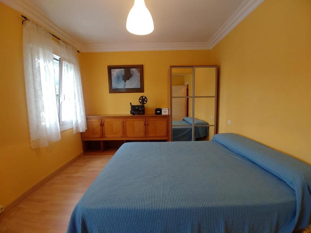a bedroom with a blue bed and a window at A casa de Xues in Pontevedra