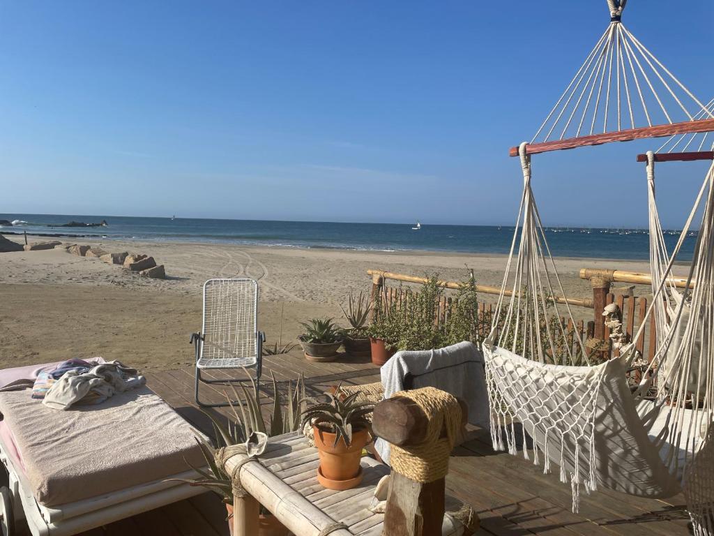 a hammock on a beach with the ocean in the background at Casa Náutica Beach Guesthouse for Kiters & Surfers in Los Órganos