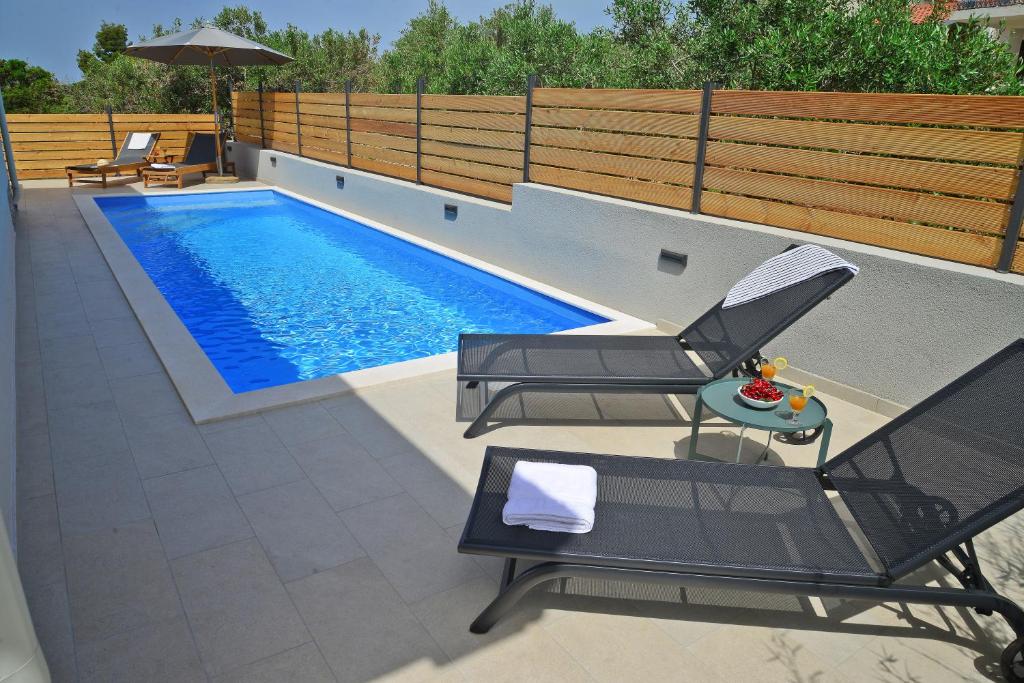 an overhead view of a swimming pool with chairs and an umbrella at Villa Cutty sark in Maslinica