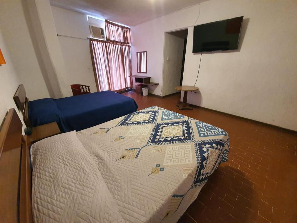 - une chambre avec un lit et une télévision dans l'établissement HOTEL PLAZA, à La Paz