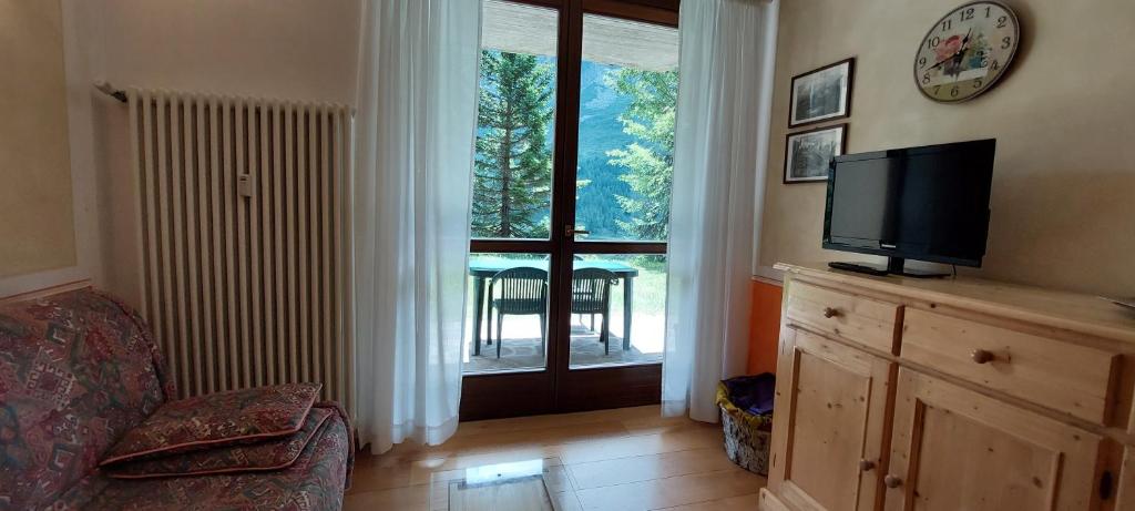 ein Wohnzimmer mit einem TV und einem großen Fenster in der Unterkunft Margherita sulla neve - trilo 200 m from slopes in Passo del Tonale