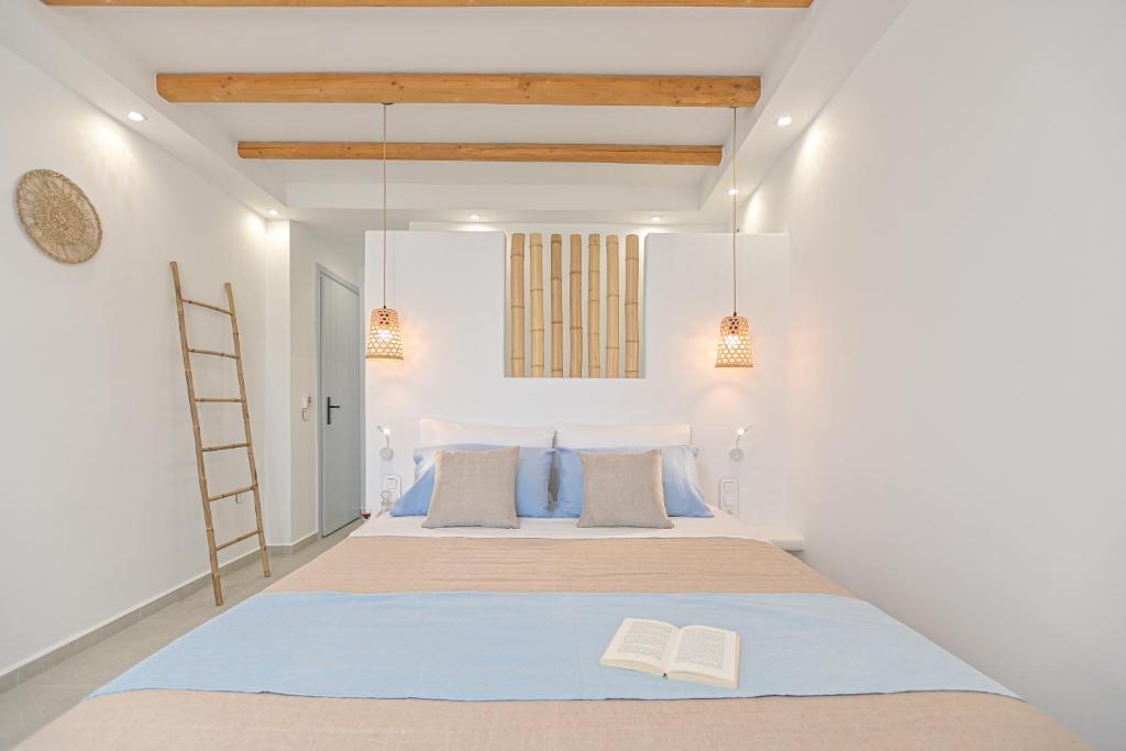 a bedroom with a large bed with two books on it at Elite Suites Naxos in Naxos Chora