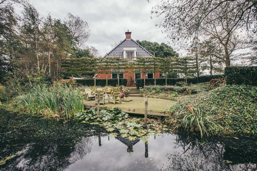 une maison avec un étang en face d'un jardin dans l'établissement Alddiel B&B, à Leeuwarden