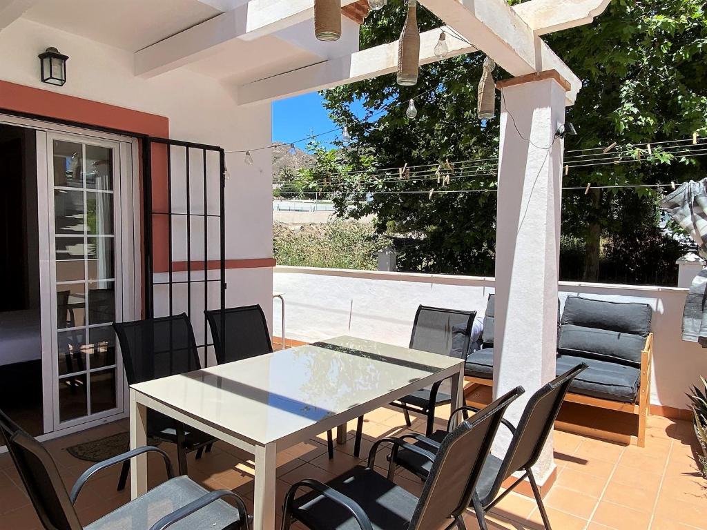 stół i krzesła na patio w obiekcie Azahara En Suite Casasol w mieście Nerja