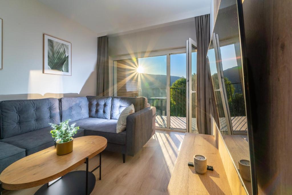 uma sala de estar com um sofá azul e uma mesa em Silver Apartments Mountain Aparts em Świeradów-Zdrój