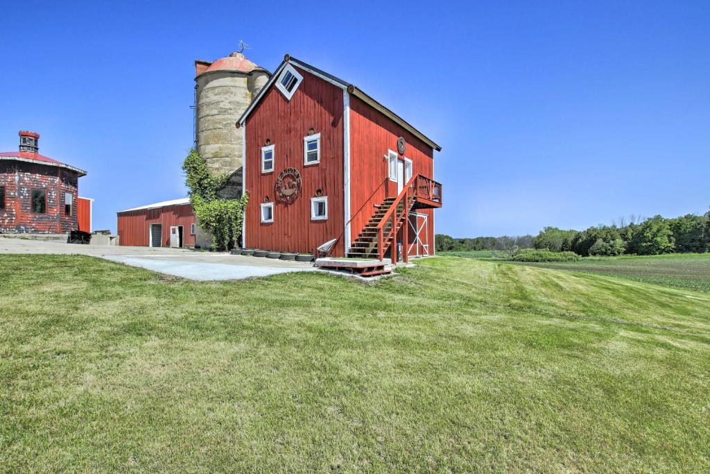 a red barn with a silo on a field at Pet-Friendly Countryside Cottage with Fire Pit! in Fond du Lac