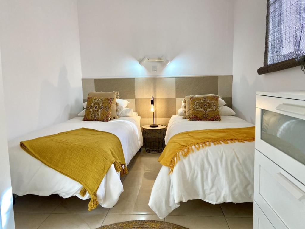 1 dormitorio con 2 camas y una lámpara en una mesa en CASA SOLE - Apartamento Playa San Juan NR. 3, en Guía de Isora
