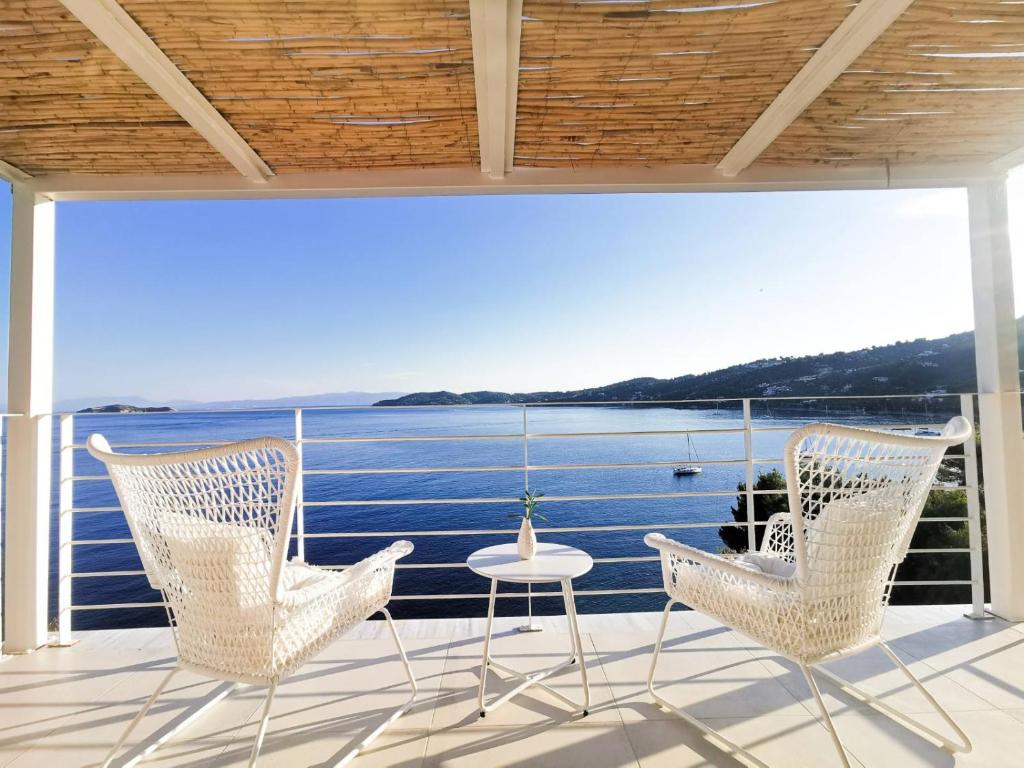 a balcony with chairs and a view of the water at Evgenia Seafront House in Skiathos