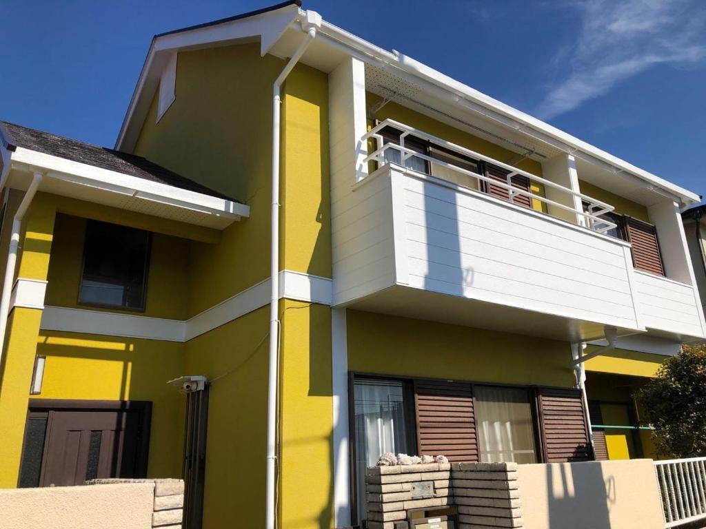 a yellow and white house with a balcony at homelike / Vacation STAY 33817 in Chiba