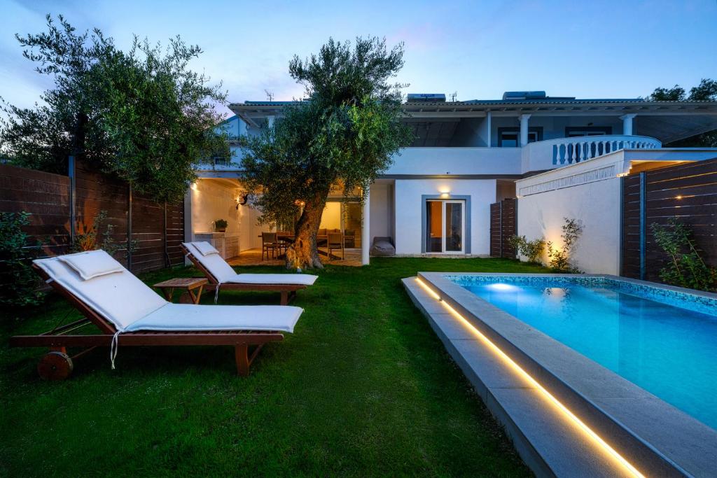 a backyard with a swimming pool and a house at Playia Villas II in Petrití