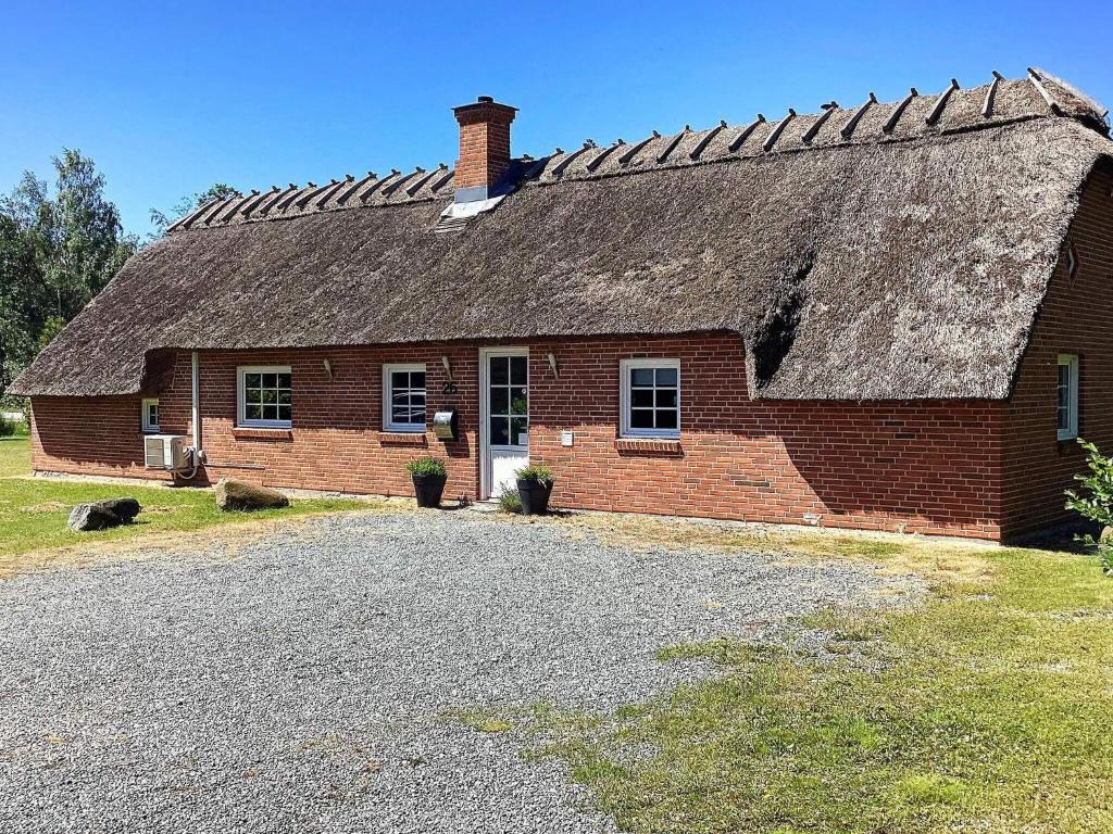 an old brick house with a thatched roof at Holiday home Væggerløse XXXVIII in Marielyst
