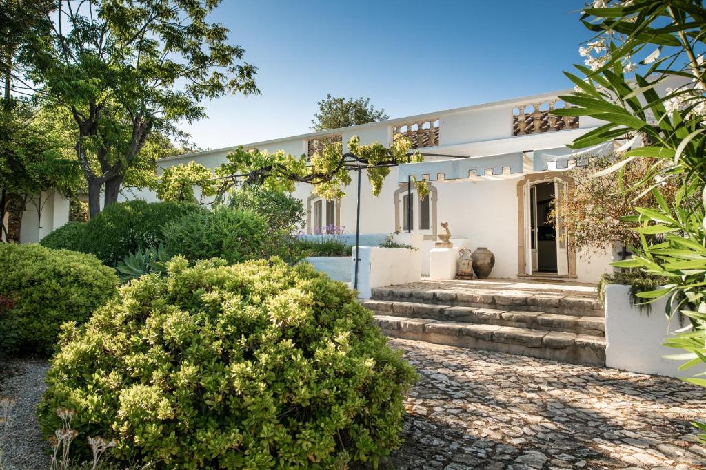 a white house with trees and bushes at Altanure - Quinta Sol d'Agua Beautiful Country Side Cottage with Private Pool in Tavira
