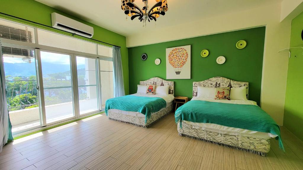 a green bedroom with two beds and a window at Locking B&amp;B台東民宿 in Taitung City