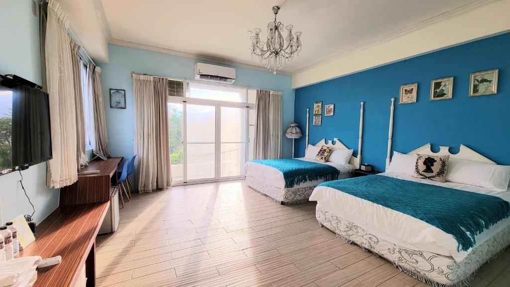台東市的住宿－Locking B&B台東民宿，一间卧室设有两张床和蓝色的墙壁