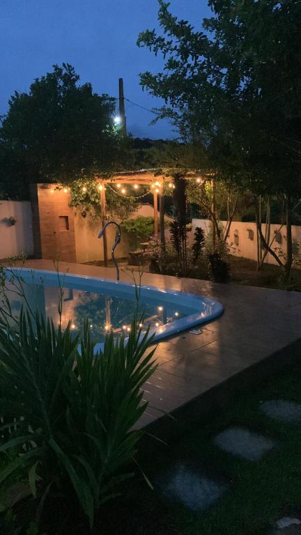 a swimming pool with lights in a yard at night at Chácara Monte das Oliveiras in Marechal Floriano