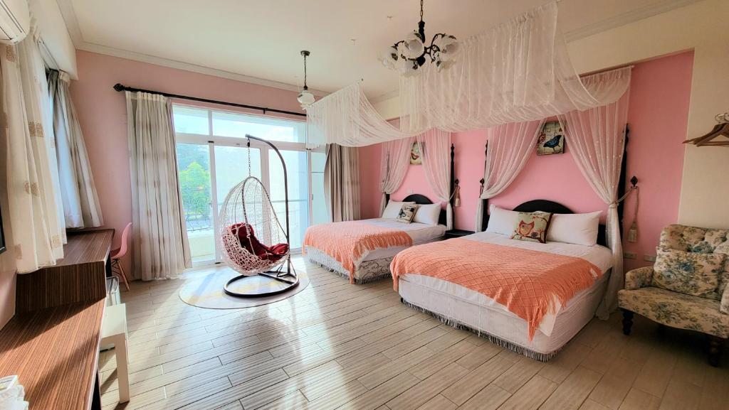 a pink bedroom with two beds and a chair at Locking B&amp;B台東民宿 in Taitung City