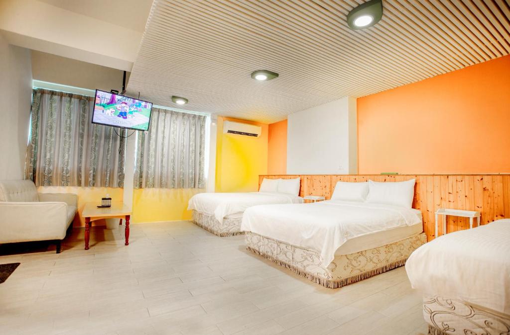 a hotel room with two beds and a flat screen tv at Locking B&amp;B台東民宿 in Taitung City