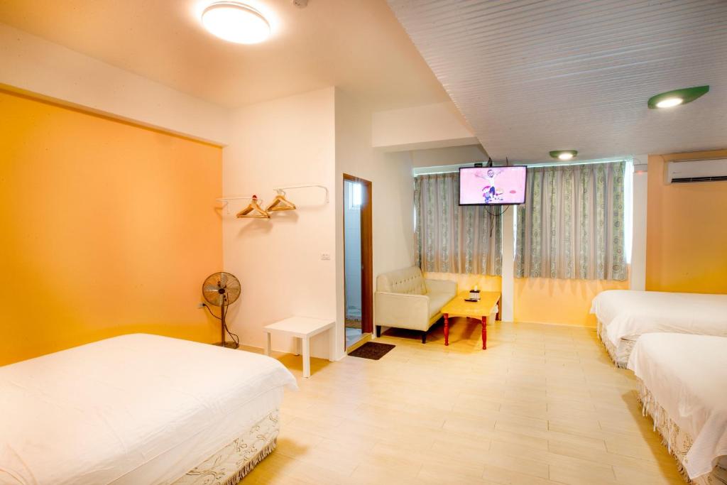 a hotel room with two beds and a tv at Locking B&amp;B台東民宿 in Taitung City