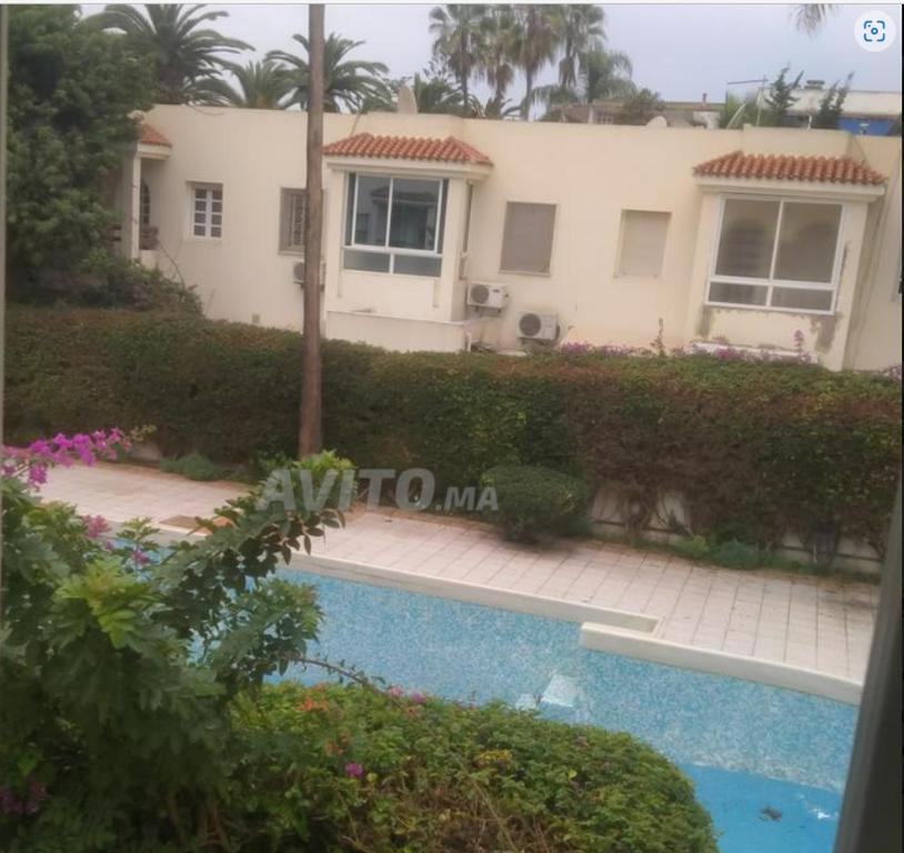 a house with a swimming pool in front of it at DUPLEX VILLA RESIDENCE LA CORNICHE juste à coté de la plage in Mohammedia