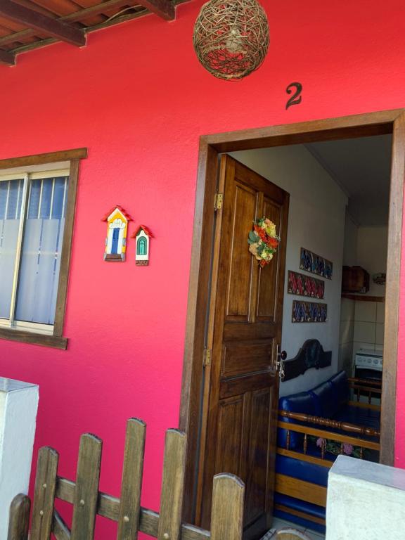 une porte menant à une chambre avec un mur rose dans l'établissement Casa quadra praia Jacaraipe!, à Jacaraípe