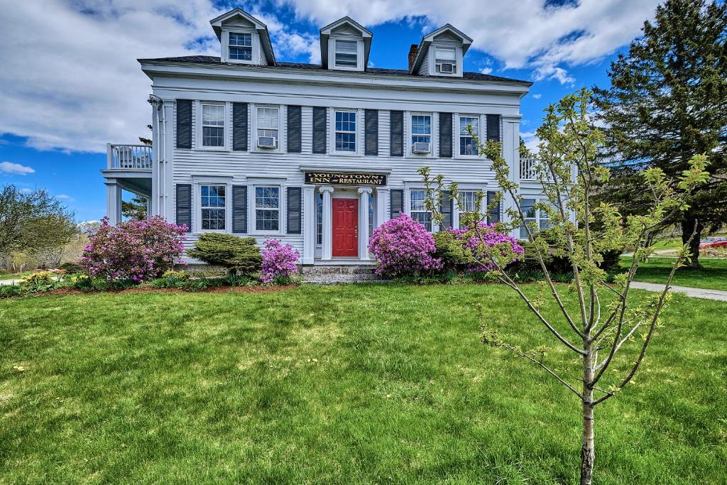 a large white house with a red door at Youngtown Inn in Youngtown