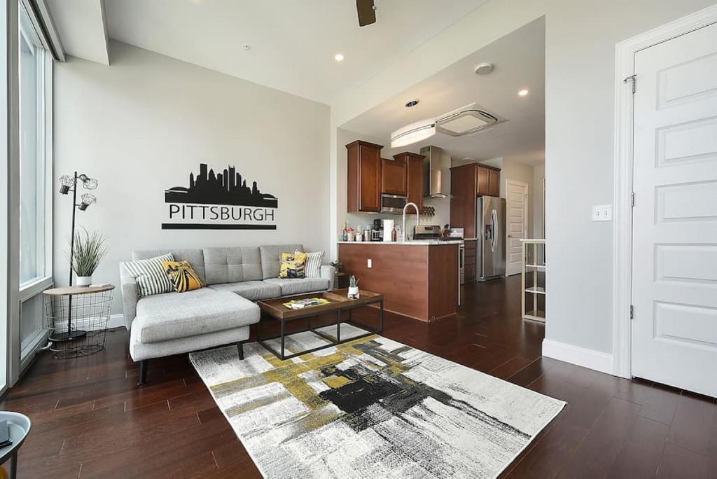 a living room with a couch and a kitchen at HostWise Stays - Free Parking Downtown - Skyline Views in Pittsburgh