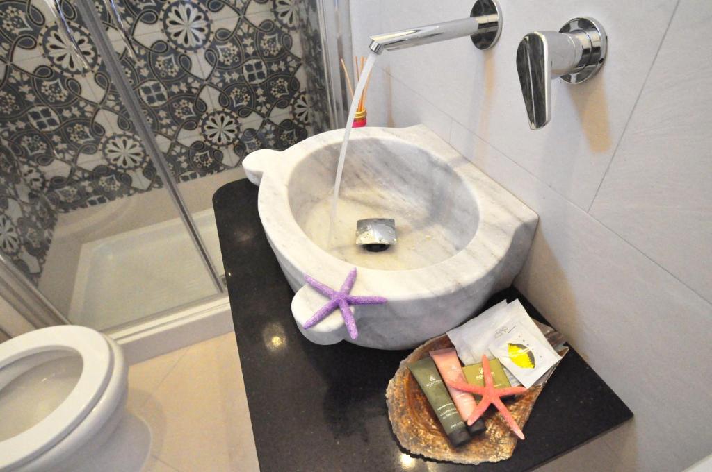 a bathroom with a sink and a toilet and a shower at Terra Murata Boutique b&b in Procida