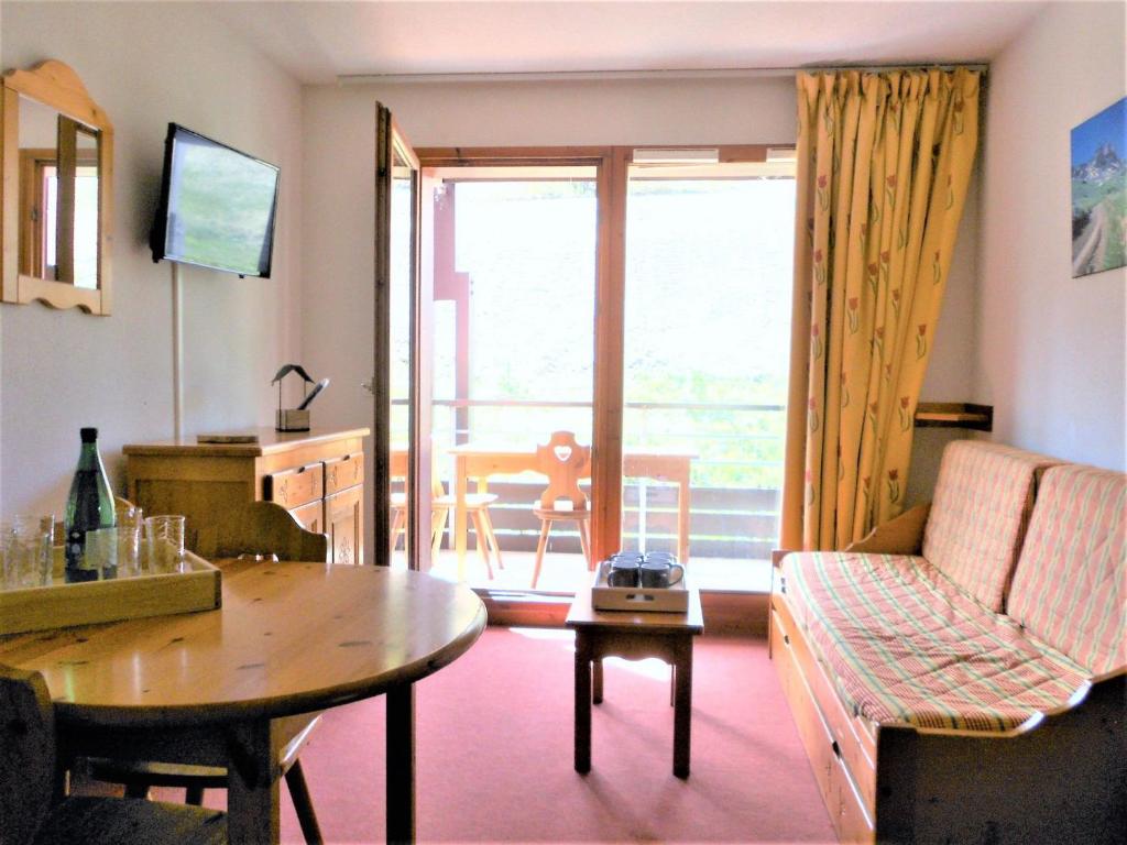 un salon avec un canapé et une table dans l'établissement Appartement T3 lumineux, balcon, accès direct aux pistes, piscine et navette gratuites - FR-1-267-199, au Corbier