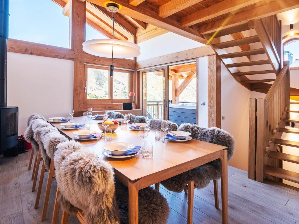 une salle à manger avec une table et des chaises en bois dans l'établissement Chalet Landenoire · Ski-in/Ski-out · Sauna & Jacuzzi · Parking · WiFi · 8 Pers. - FR-1-344-777, à Saint-Martin-de-Belleville