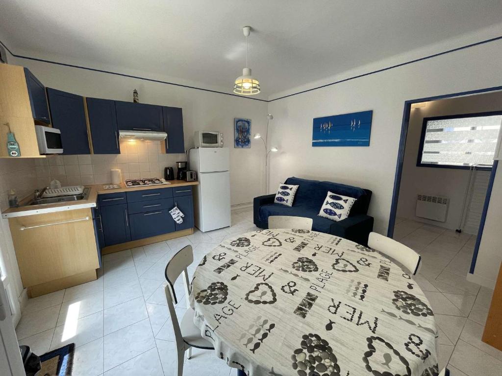 une cuisine et une salle à manger avec une table et des chaises dans l'établissement Appartement Moderne 2 Pièces + Cabine, Terrasse, Proche Plage – Saint-Jean-de-Monts - FR-1-224C-204, à Saint-Jean-de-Monts