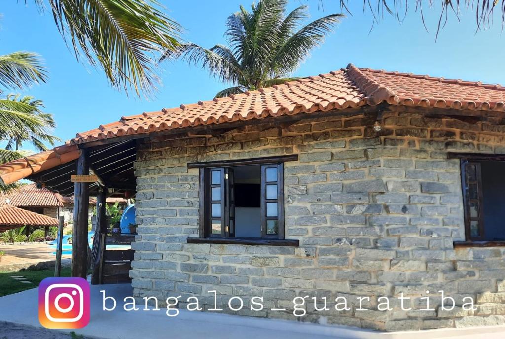 プラドにあるBangalô Aconchegante de Frente para o Marの瓦屋根の小石造家