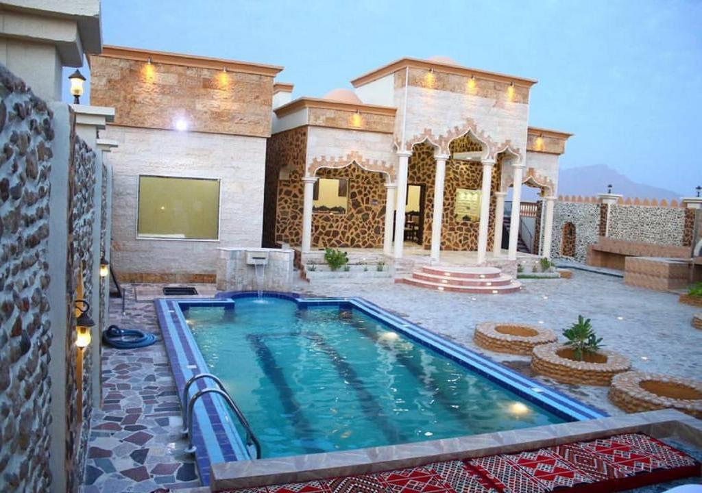 a swimming pool in front of a house at استراحة ابهار in Jadīd