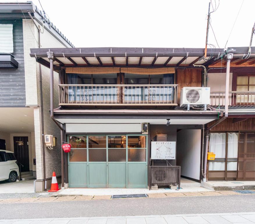 a building with a balcony on top of it at unattended check-in accommodation in Gujo Hachiman in Gujo
