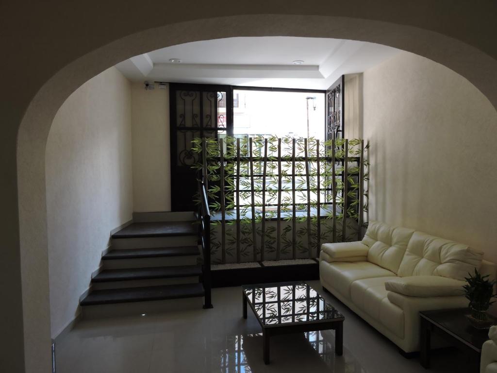 a living room with a couch and a staircase at Casa Jasave Hotel in Tequisquiapan