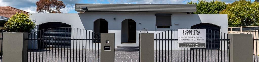 una puerta frente a un edificio blanco con una señal en Benalla Apartments, en Benalla