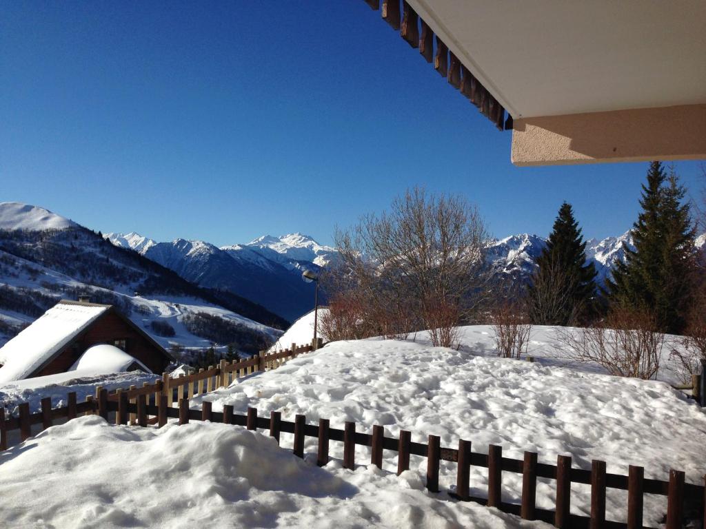 a fence covered in snow with mountains in the background at Appartement avec terrasse magnifique vue montagne in Saint-François-Longchamp