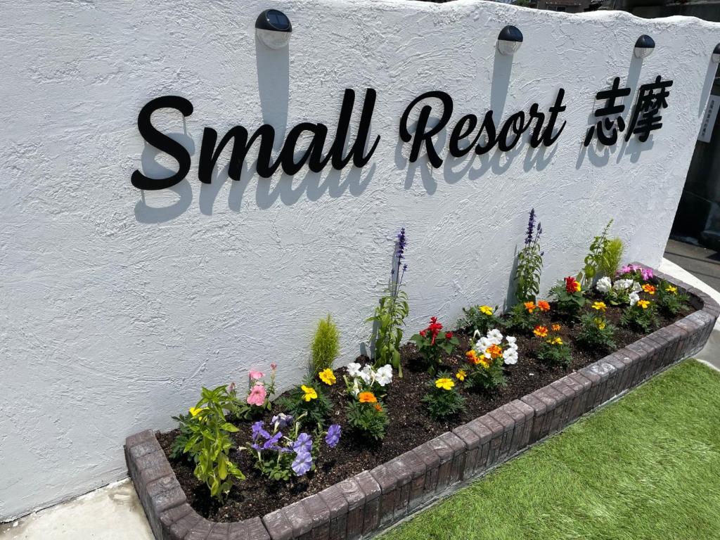 ein kleines Antwortschild mit Blumen im Garten in der Unterkunft Small Resort Shima - Vacation STAY 96429v in Shima