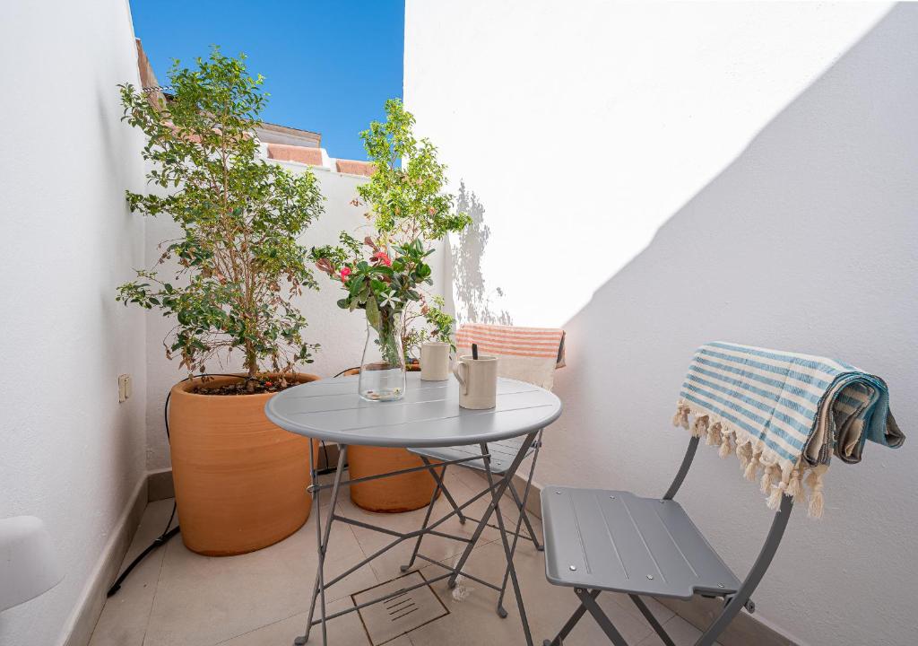 uma pequena mesa e cadeiras numa varanda com plantas em Málaga Centro Terraza 4-D em Málaga