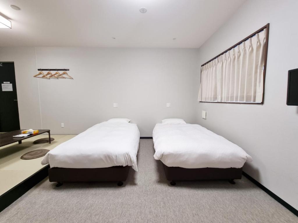 Posteľ alebo postele v izbe v ubytovaní KYU KYU HOTEL