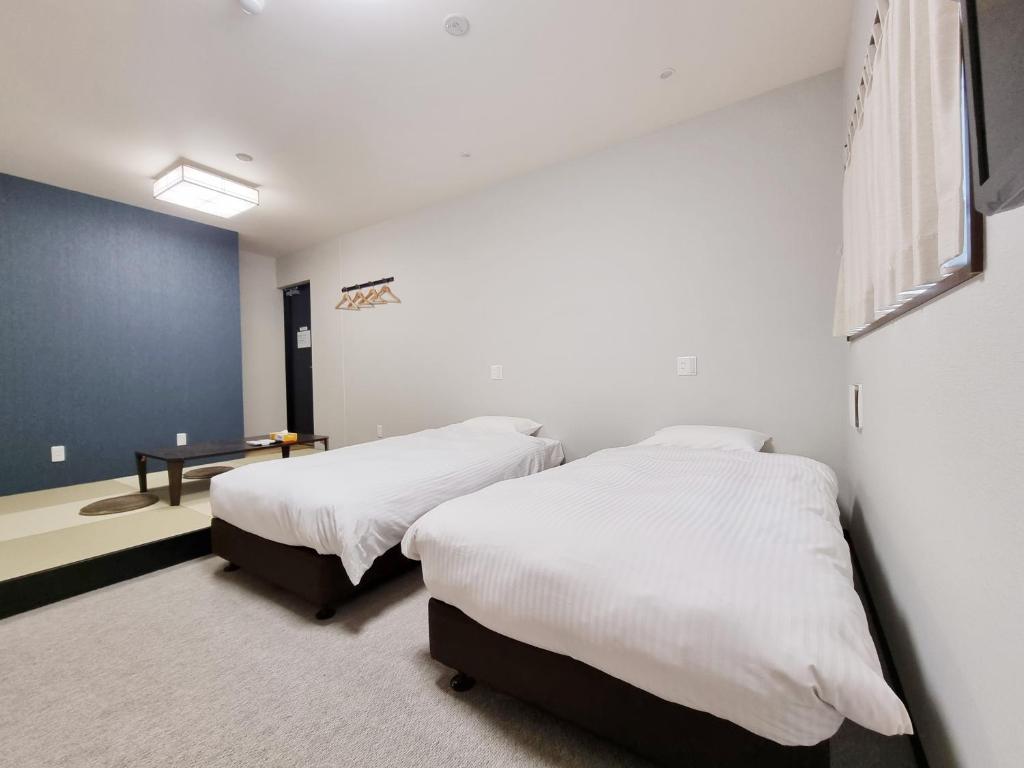 Posteľ alebo postele v izbe v ubytovaní KYU KYU HOTEL