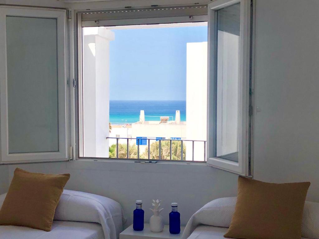 una sala de estar con una ventana con vistas al océano en TarifaMiCasa Mar Tirreno, en Tarifa