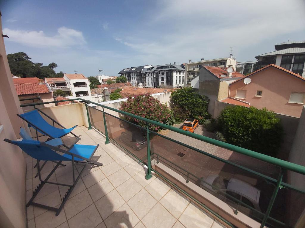 une chaise bleue sur un balcon avec vue sur la ville dans l'établissement Centre, Grand T2 balcon Pkg, plage gare 600m, Trés calme, à Arcachon